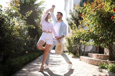 Lovely young couple dancing together in park on sunny day Photo of Lovely young couple dancing together in park on sunny day