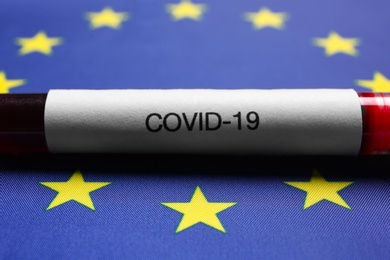Test tube with blood sample on European Union flag background, closeup. Coronavirus outbreak Photo of Test tube with blood sample on European Union flag background, closeup. Coronavirus outbreak