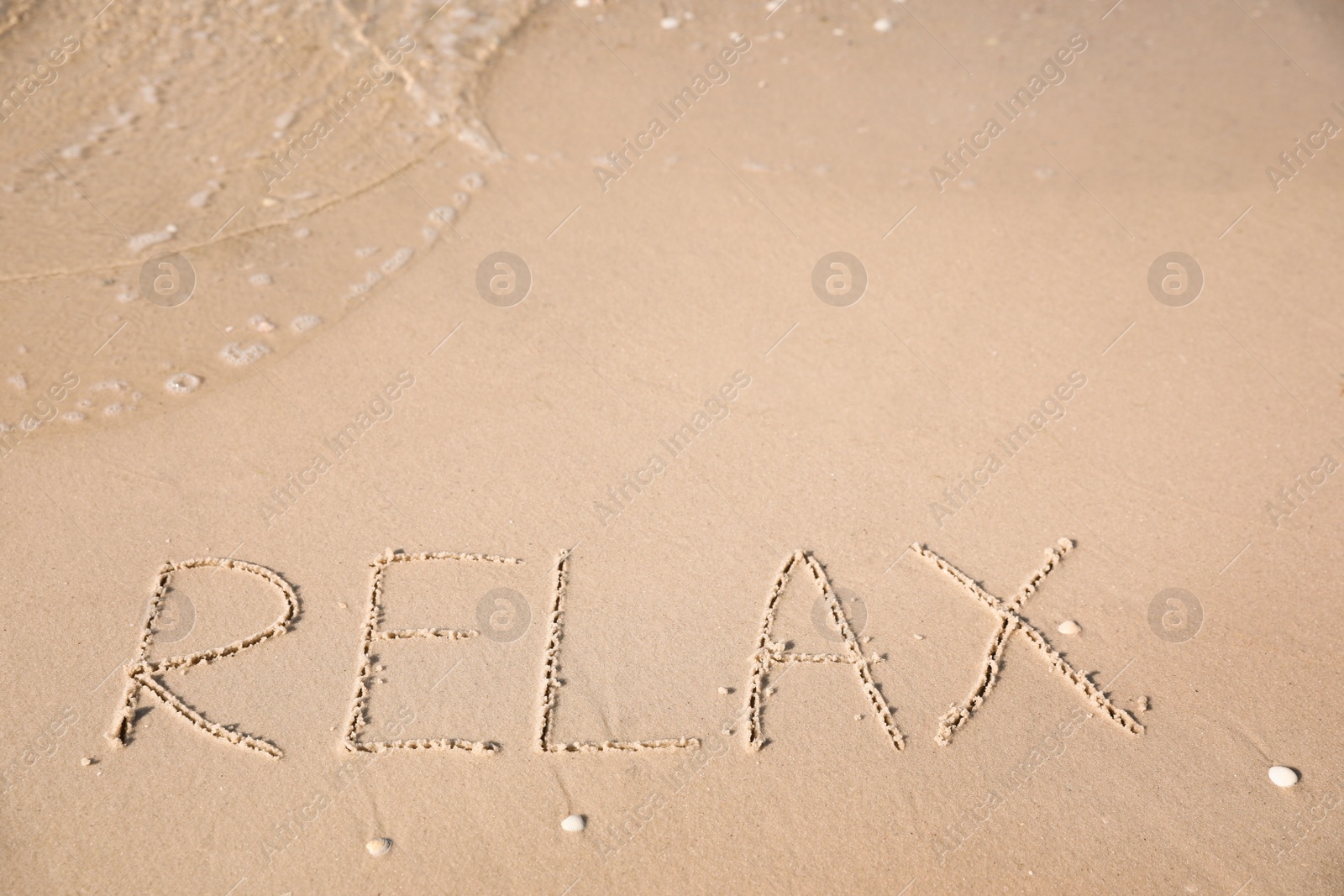 Word Relax written on sand at beach Photo of Word Relax written on sand at beach