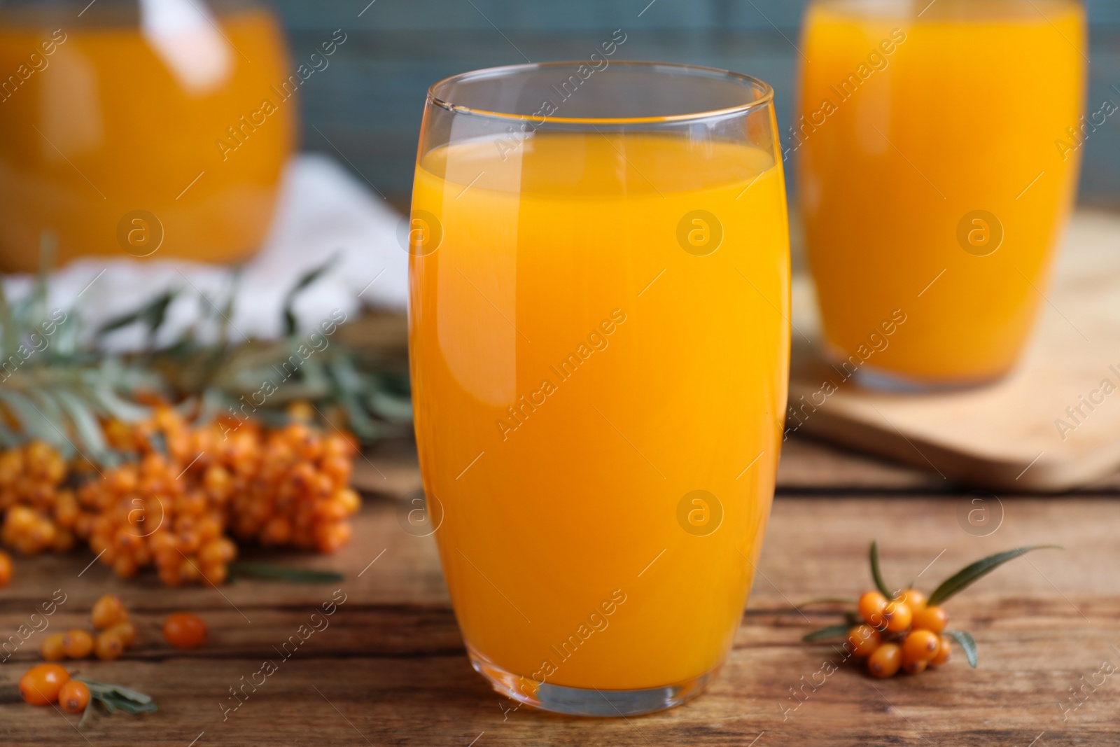 Sea buckthorn juice and fresh berries on wooden table, closeup Photo of Sea buckthorn juice and fresh berries on wooden table, closeup