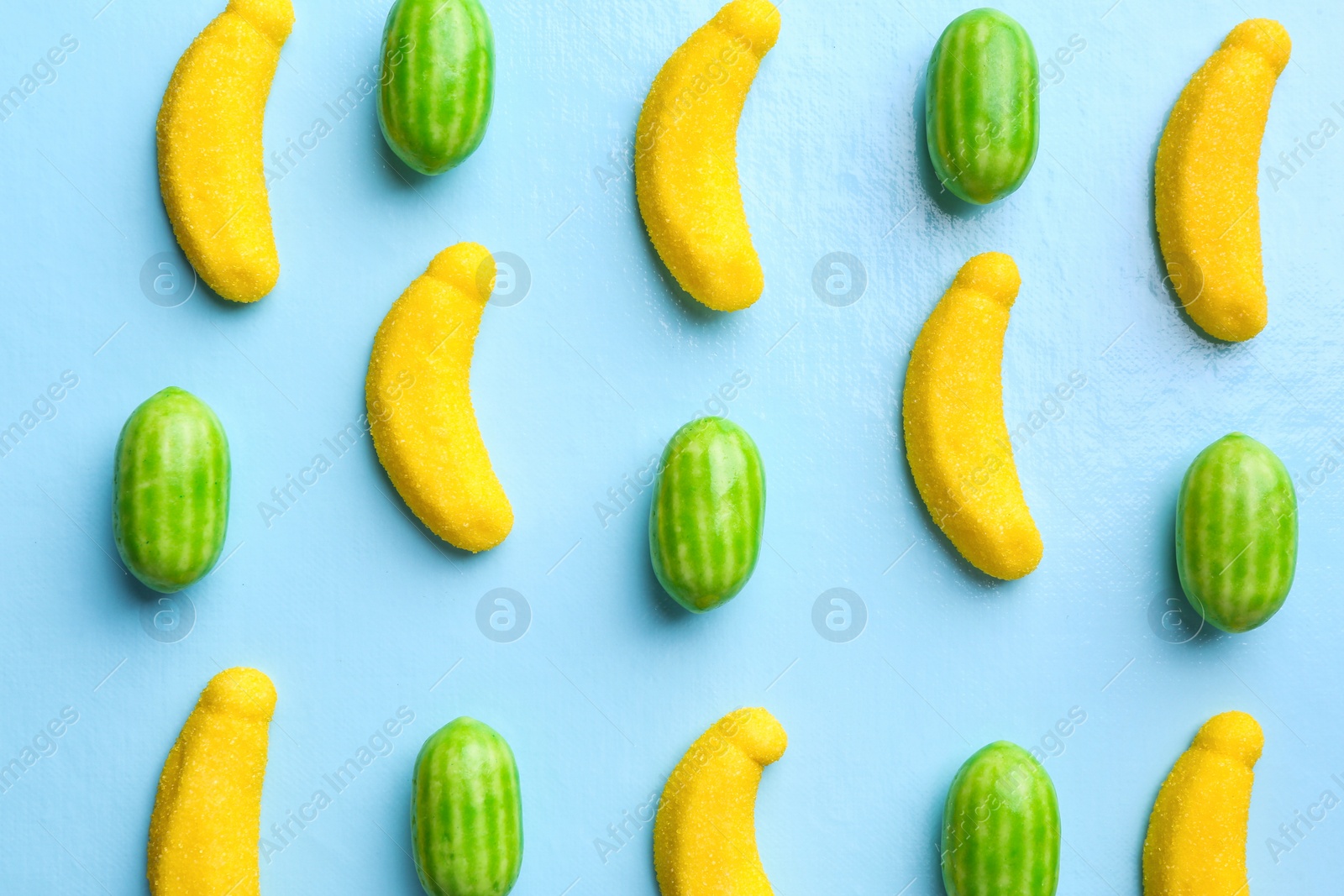 Many delicious candies on light blue background, flat lay Photo of Many delicious candies on light blue background, flat lay