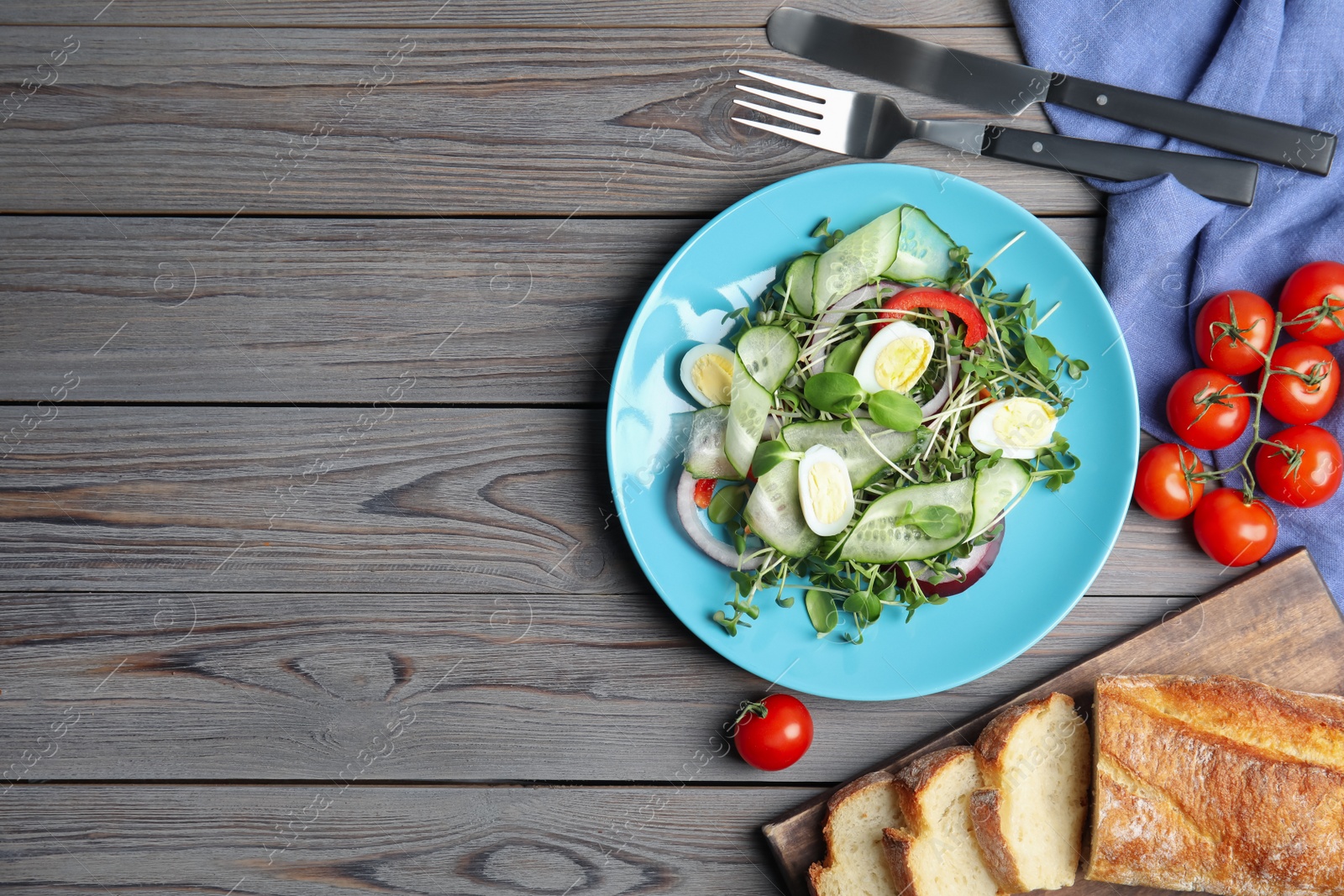 Salad with fresh organic microgreen in plate on wooden table, flat lay. Space for text Photo of Salad with fresh organic microgreen in plate on wooden table, flat lay. Space for text