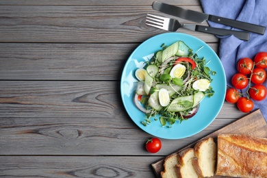 Salad with fresh organic microgreen in plate on wooden table, flat lay. Space for text Photo of Salad with fresh organic microgreen in plate on wooden table, flat lay. Space for text
