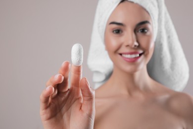 Woman with silkworm cocoon against light grey background, focus on hand. Skin care routine Photo of Woman with silkworm cocoon against light grey background, focus on hand. Skin care routine
