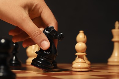 Photo of Woman moving chess piece on board, closeup