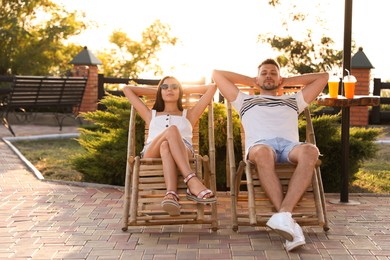 Couple resting together in deck chairs outdoors Image of Couple resting together in deck chairs outdoors