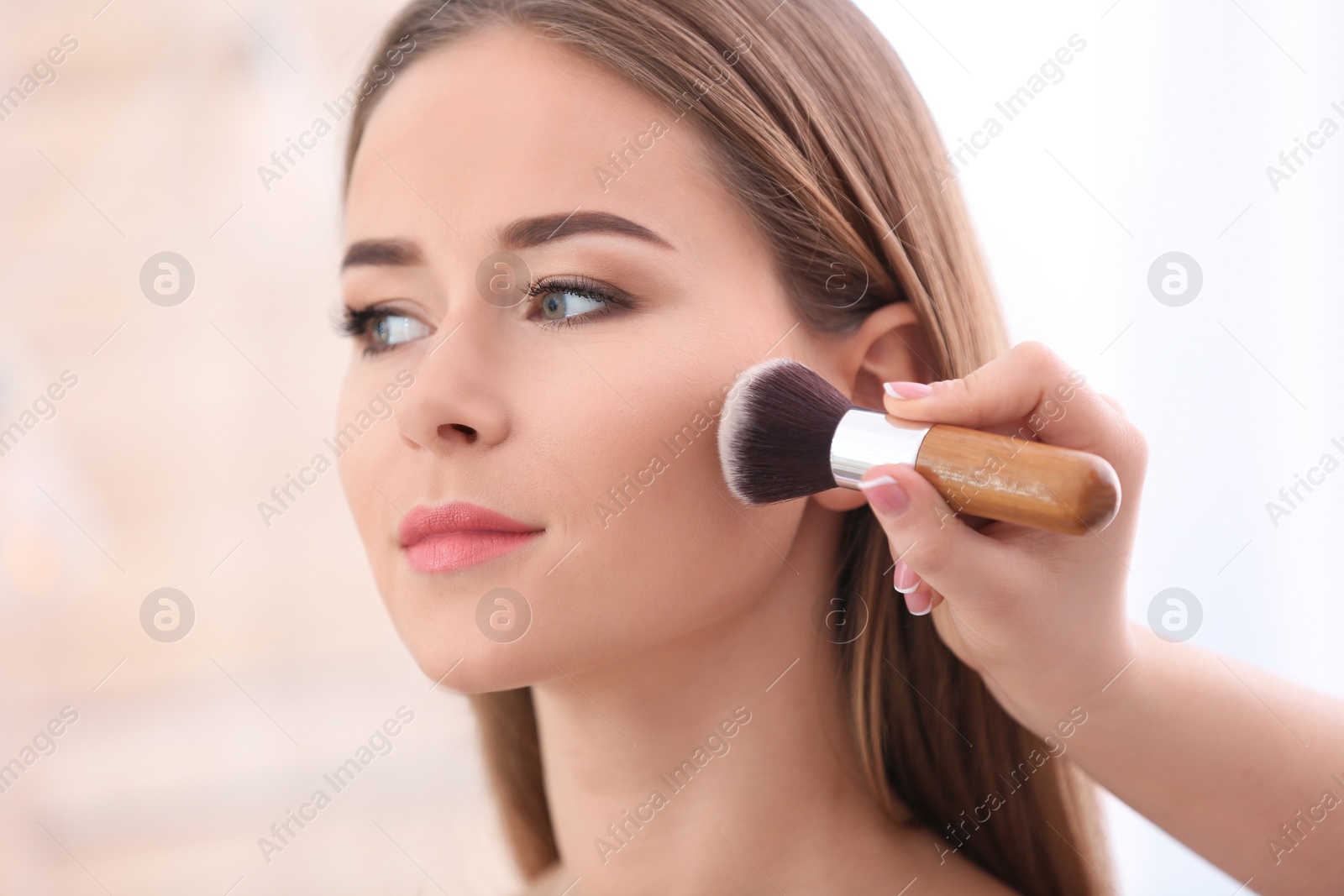 Professional visage artist applying makeup on woman's face in salon, closeup Photo of Professional visage artist applying makeup on woman's face in salon, closeup
