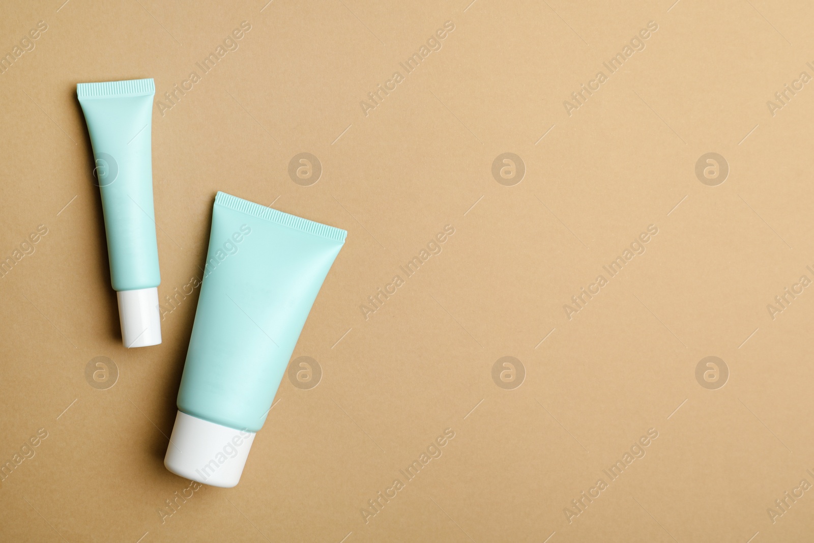 Set of luxury cosmetic products on light brown background, flat lay. Space for text Photo of Set of luxury cosmetic products on light brown background, flat lay. Space for text