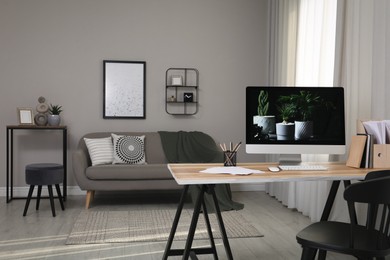 Comfortable workplace with computer on wooden desk in modern office. Interior design Photo of Comfortable workplace with computer on wooden desk in modern office. Interior design