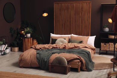 Stylish room interior with large bed near brown wall Photo of Stylish room interior with large bed near brown wall