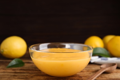 Delicious lemon curd in glass bowl on wooden table Photo of Delicious lemon curd in glass bowl on wooden table
