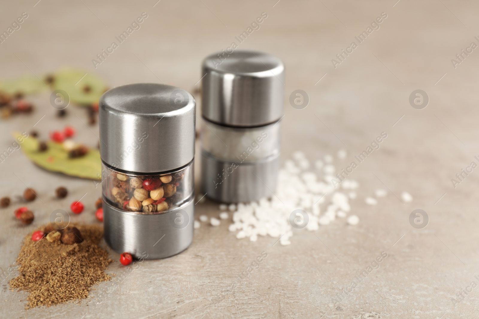 Salt and pepper shakers on light grey table, closeup. Space for text Photo of Salt and pepper shakers on light grey table, closeup. Space for text