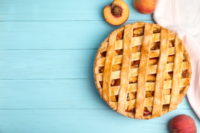 Delicious fresh peach pie on light blue wooden table, flat lay. Space for text Photo of Delicious fresh peach pie on light blue wooden table, flat lay. Space for text