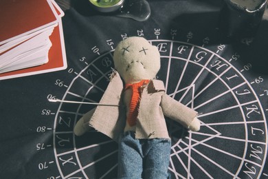 Voodoo doll pierced with needle on table. Curse ceremony Photo of Voodoo doll pierced with needle on table. Curse ceremony