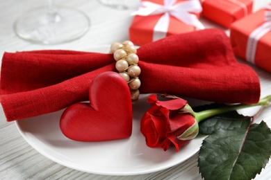 Beautiful place setting with decorative heart on white wooden table, closeup view. Valentine's day romantic dinner Photo of Beautiful place setting with decorative heart on white wooden table, closeup view. Valentine's day romantic dinner