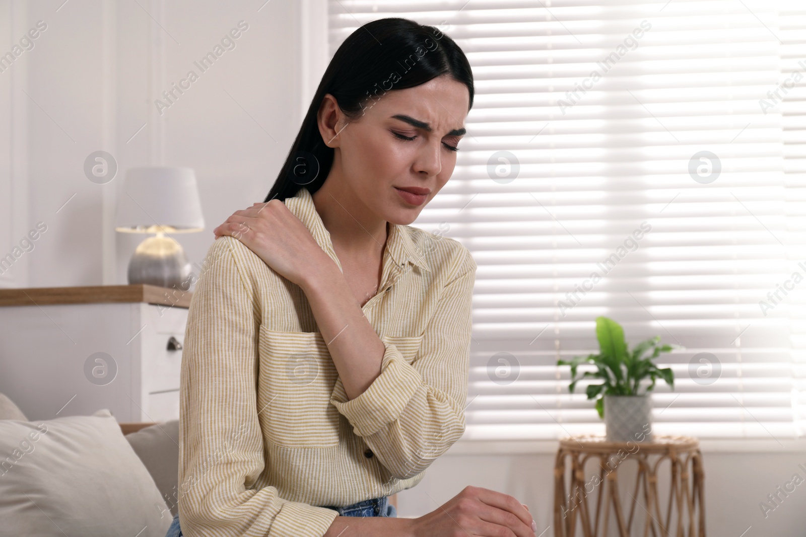 Woman suffering from shoulder pain at home Photo of Woman suffering from shoulder pain at home