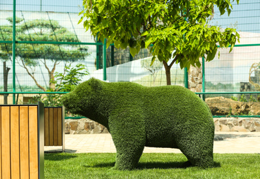Photo of Beautiful bear shaped topiary at zoo on sunny day. Landscape gardening