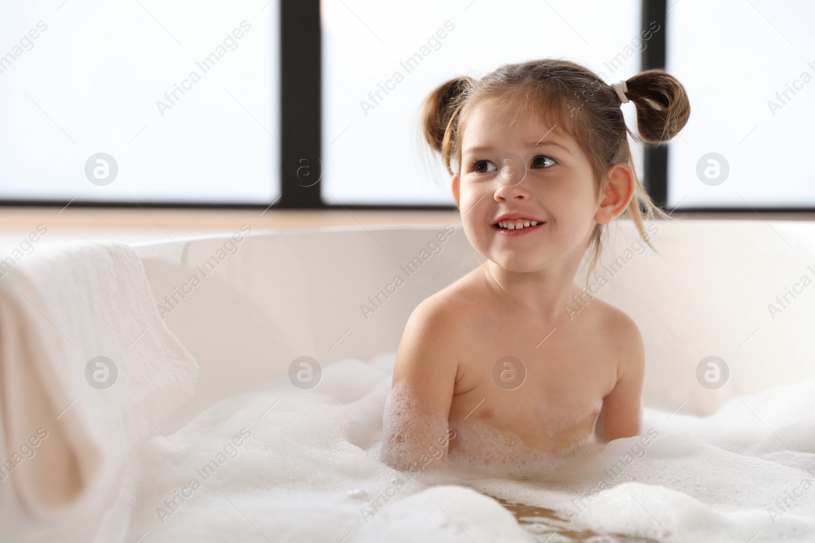 Cute little girl taking bubble bath at home Photo of Cute little girl taking bubble bath at home