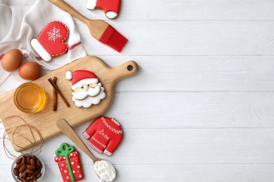 Delicious Christmas cookies and ingredients on white wooden table, flat lay with space for text Photo of Delicious Christmas cookies and ingredients on white wooden table, flat lay with space for text
