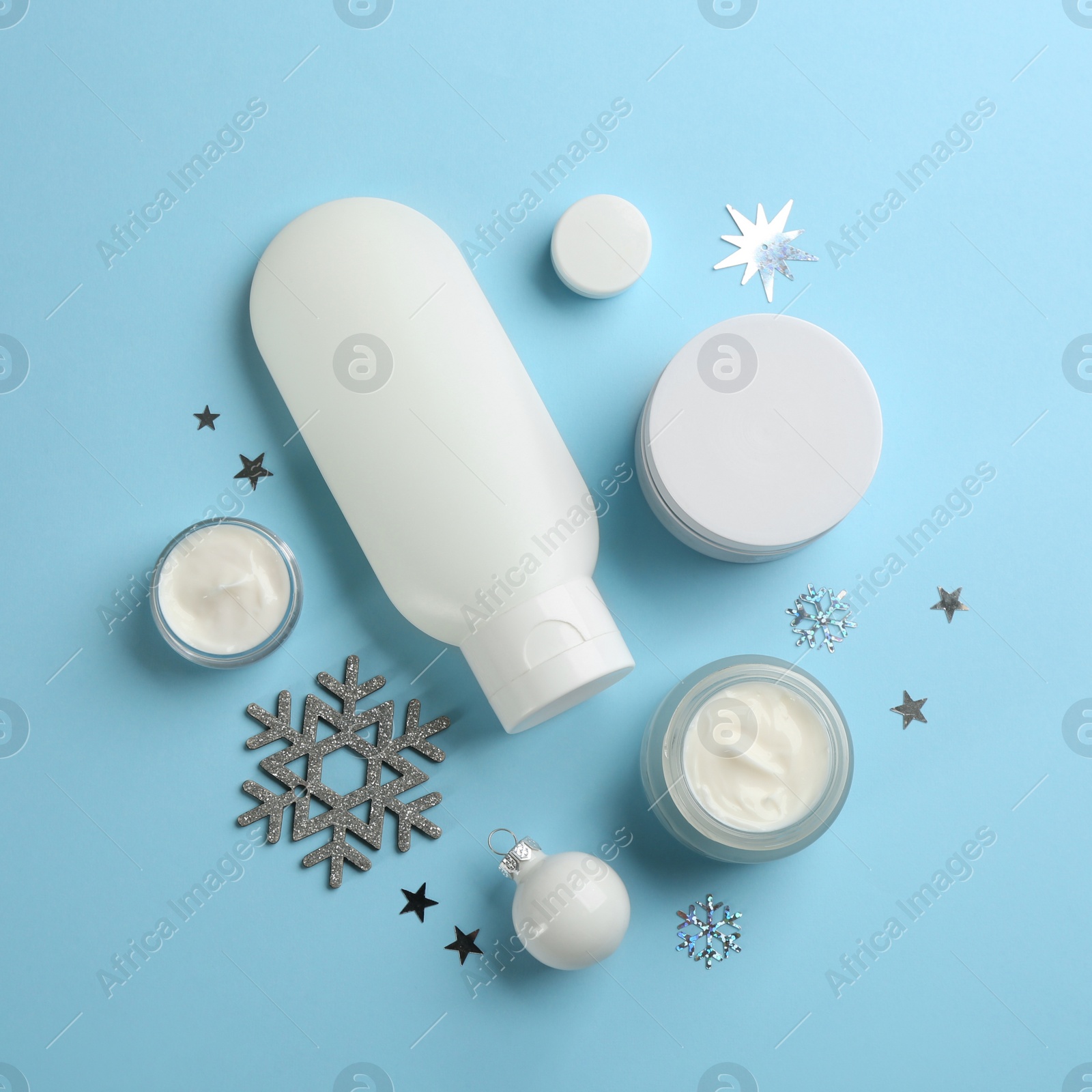 Photo of Flat lay composition with different cosmetic products on light blue background. Winter care