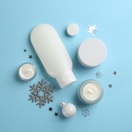 Flat lay composition with different cosmetic products on light blue background. Winter care Photo of Flat lay composition with different cosmetic products on light blue background. Winter care