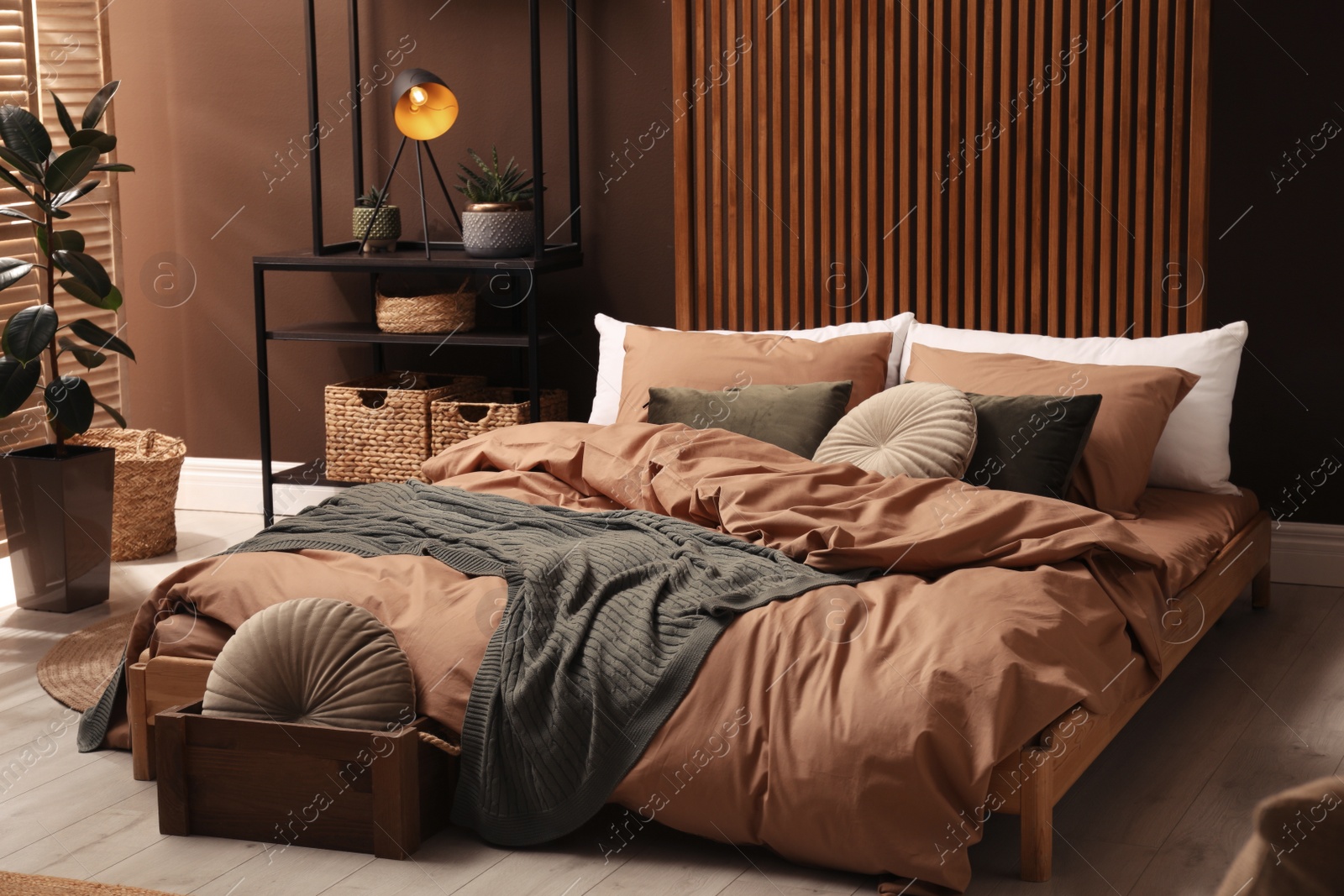 Stylish room interior with large bed near brown wall Photo of Stylish room interior with large bed near brown wall