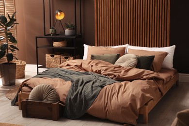 Stylish room interior with large bed near brown wall Photo of Stylish room interior with large bed near brown wall