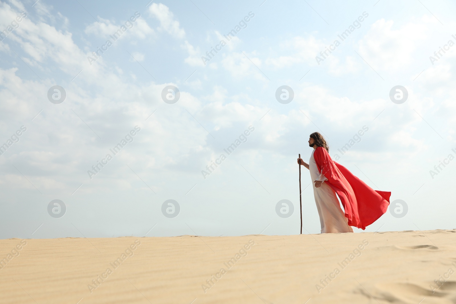 Jesus Christ walking with stick in desert. Space for text Photo of Jesus Christ walking with stick in desert. Space for text