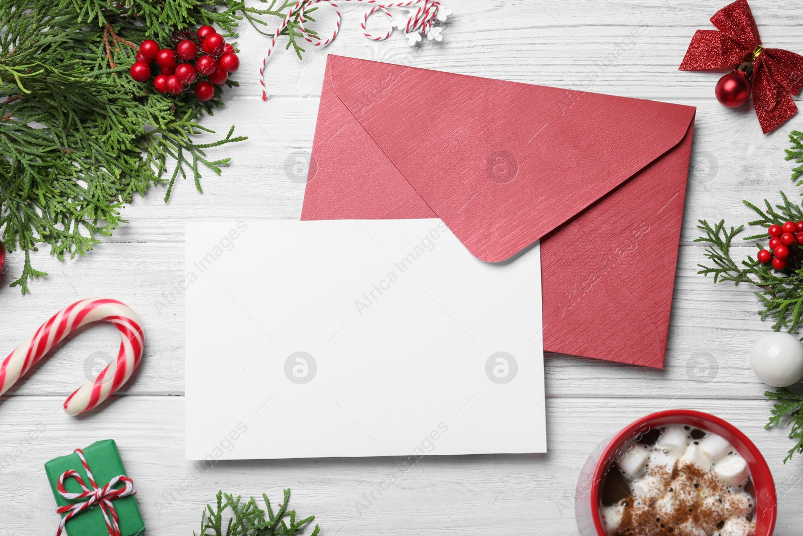 Photo of Flat lay composition with Christmas decor and blank card on white wooden background. Space for text