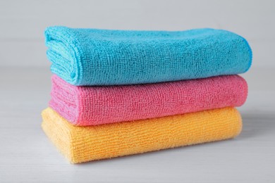 Stack of colorful microfiber cloths on white table, closeup Photo of Stack of colorful microfiber cloths on white table, closeup