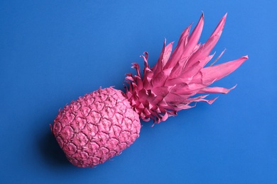 Pink pineapple on blue background, top view. Creative concept Photo of Pink pineapple on blue background, top view. Creative concept