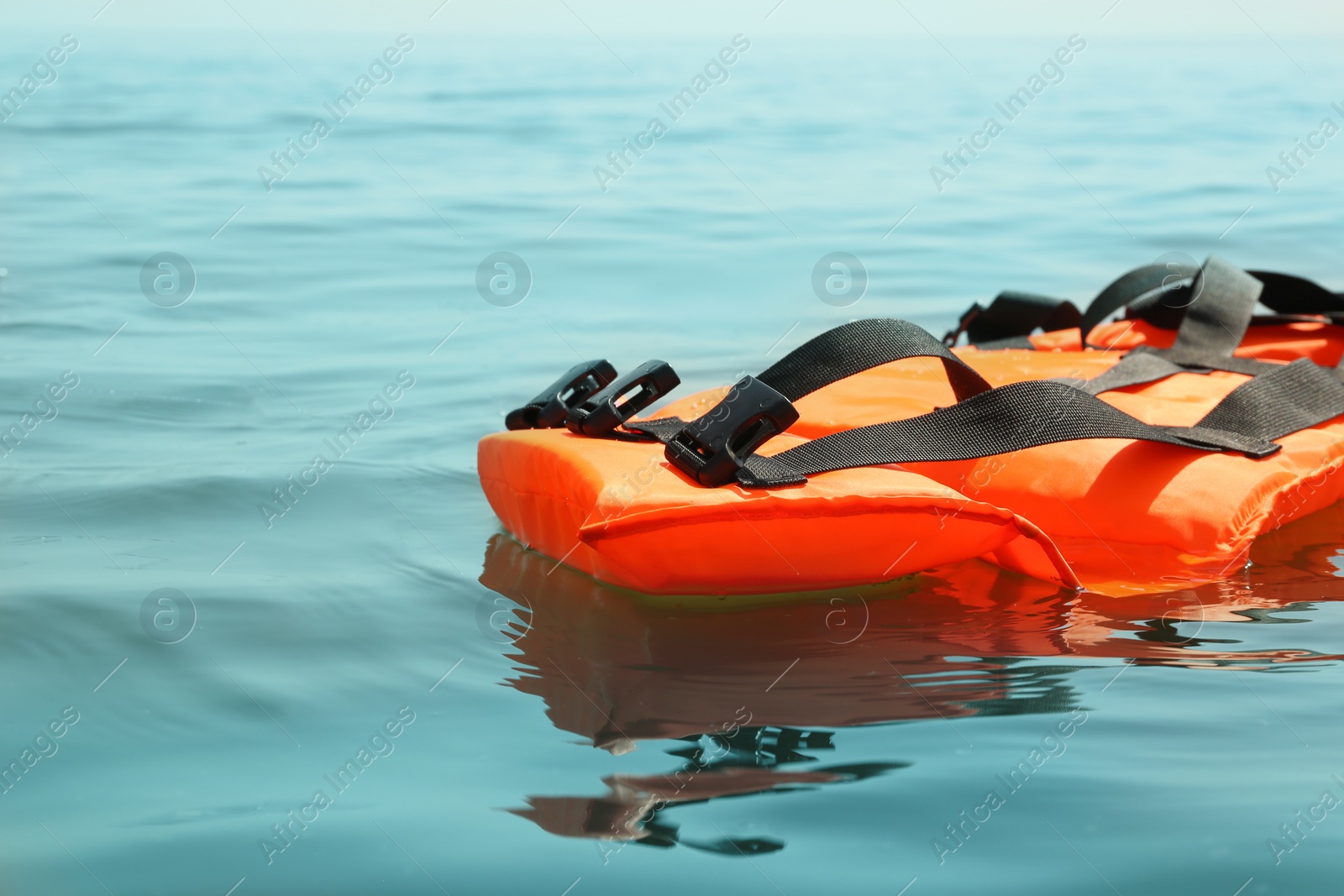 Orange life jacket floating in sea. Emergency rescue equipment Photo of Orange life jacket floating in sea. Emergency rescue equipment