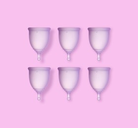 Image of  Many purple menstrual cups on pink background, flat lay 