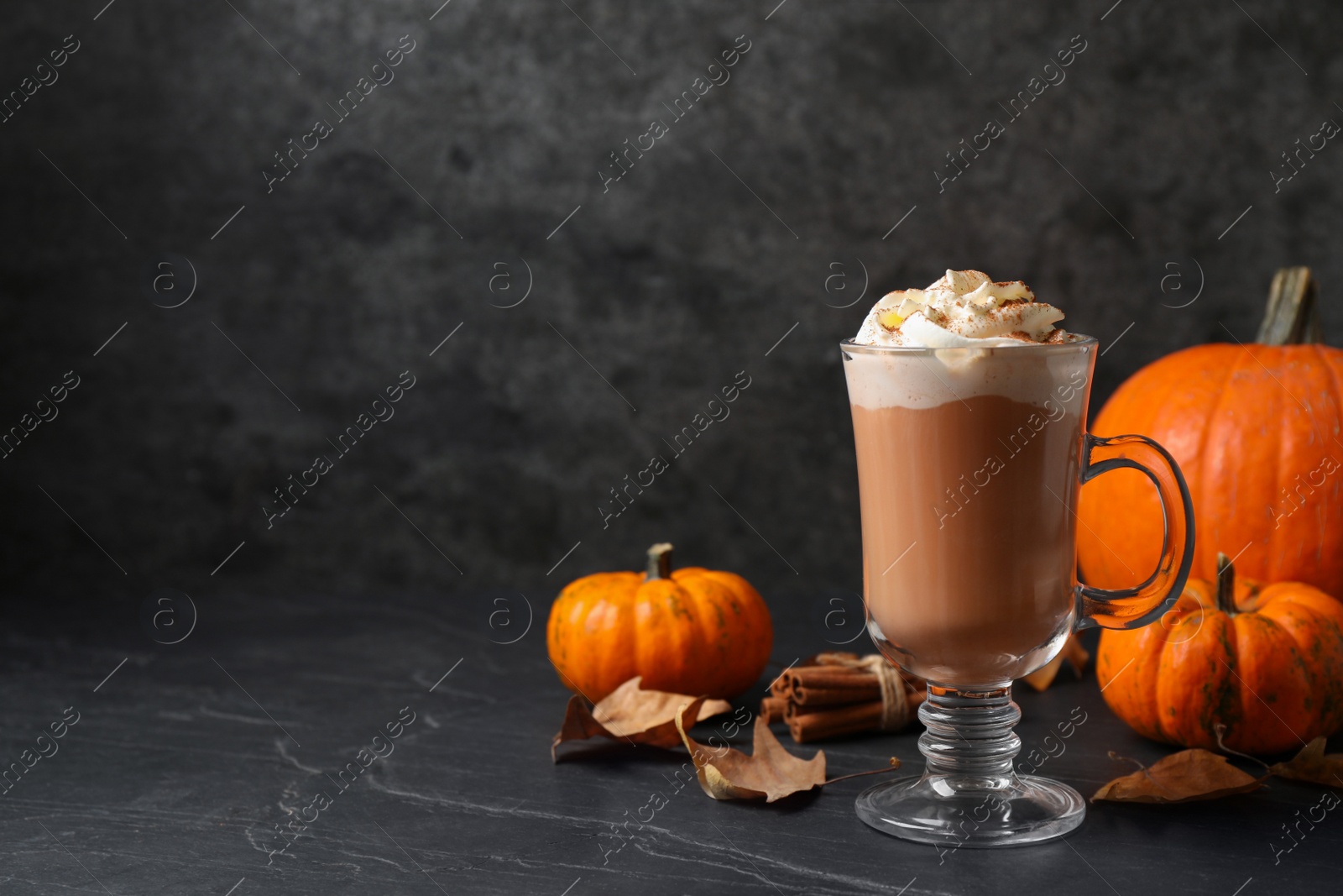 Delicious pumpkin latte on black slate table. Space for text Photo of Delicious pumpkin latte on black slate table. Space for text