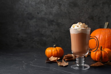 Delicious pumpkin latte on black slate table. Space for text Photo of Delicious pumpkin latte on black slate table. Space for text