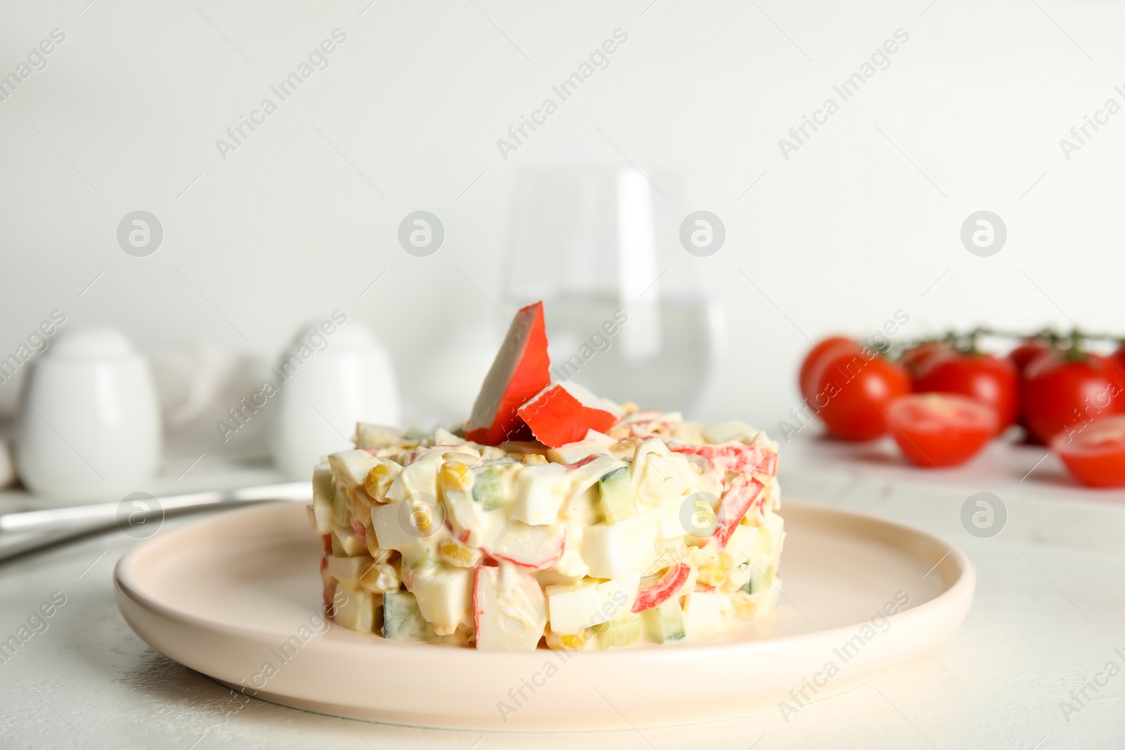 Delicious salad with fresh crab sticks on white table Photo of Delicious salad with fresh crab sticks on white table