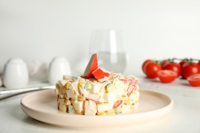 Delicious salad with fresh crab sticks on white table Photo of Delicious salad with fresh crab sticks on white table