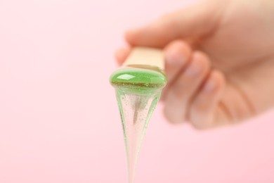 Woman holding spatula with hot depilatory wax on light background, closeup Photo of Woman holding spatula with hot depilatory wax on light background, closeup