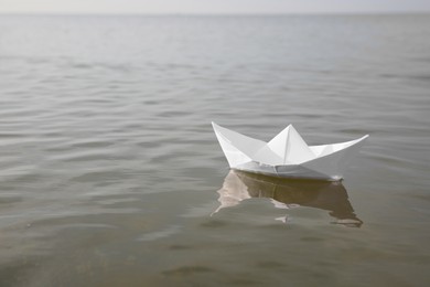 White paper boat on water surface, space for text Photo of White paper boat on water surface, space for text