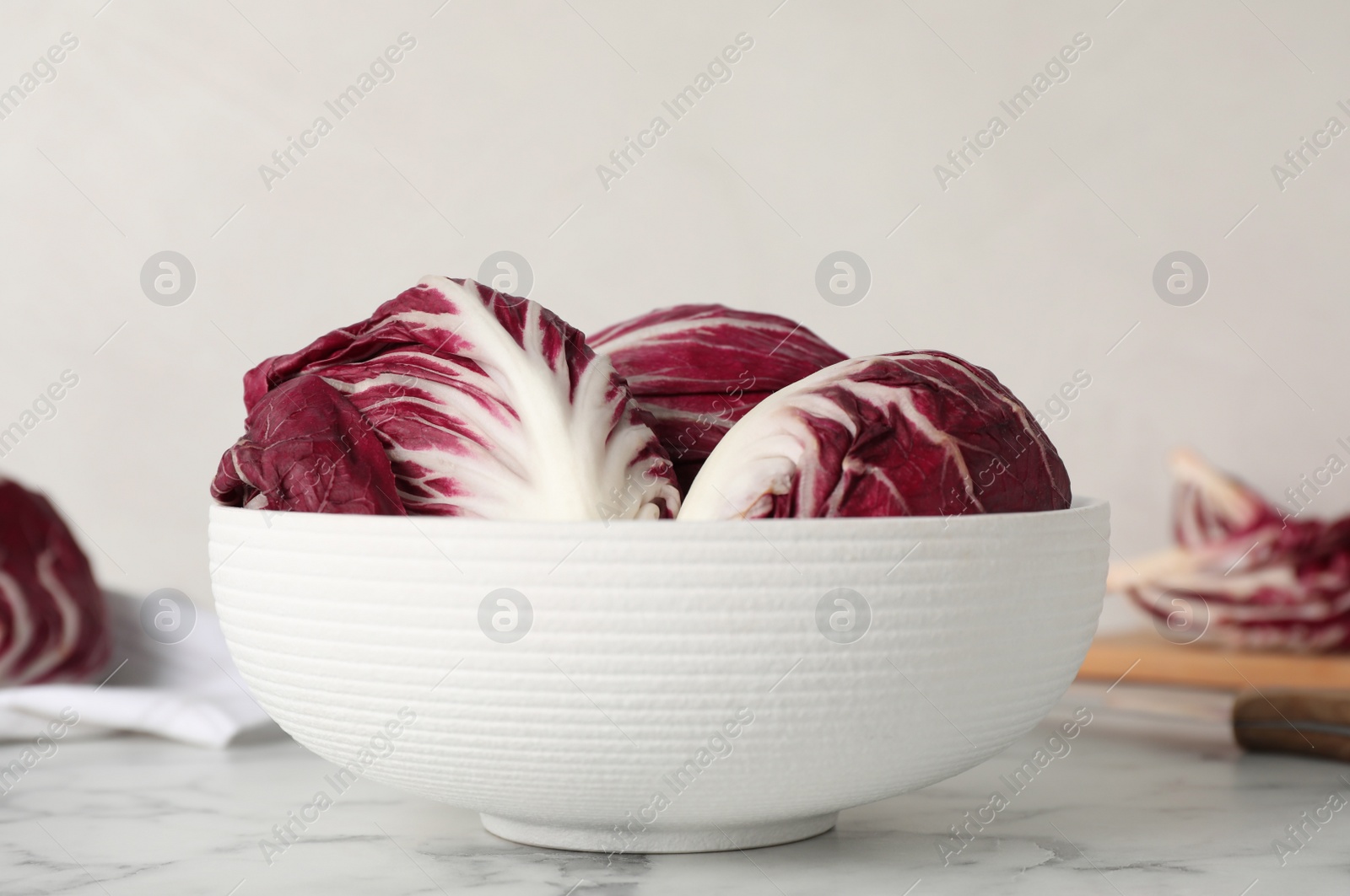 Whole fresh ripe radicchios on white marble table Photo of Whole fresh ripe radicchios on white marble table