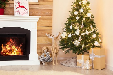 Beautiful decorated Christmas tree with skirt and gifts in room Photo of Beautiful decorated Christmas tree with skirt and gifts in room