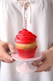 Woman holding stand with birthday cupcake, closeup Photo of Woman holding stand with birthday cupcake, closeup