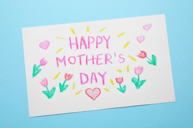 Handmade greeting card for Mother's day on light blue background, top view Photo of Handmade greeting card for Mother's day on light blue background, top view
