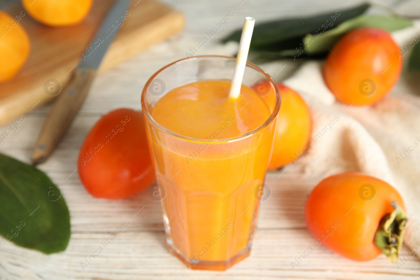Tasty persimmon smoothie and fresh fruits on white wooden table, closeup Photo of Tasty persimmon smoothie and fresh fruits on white wooden table, closeup
