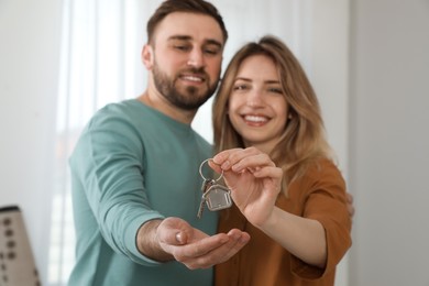 Happy young couple with key in new house, focus on hands Photo of Happy young couple with key in new house, focus on hands
