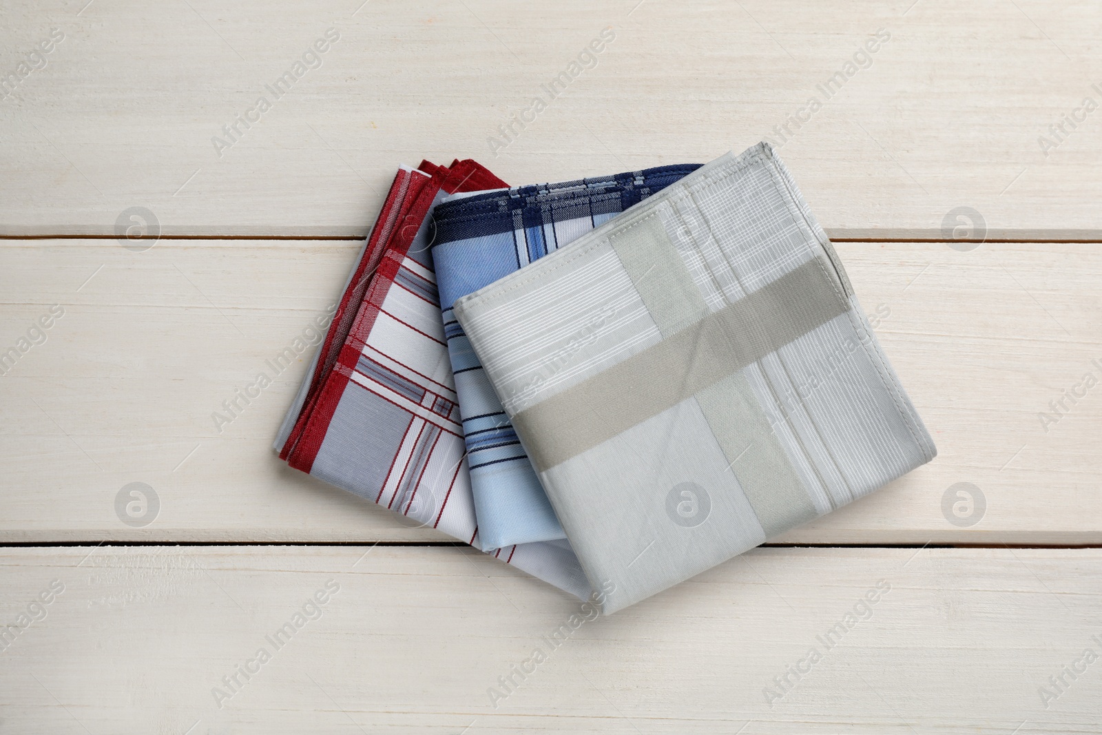 Stylish handkerchiefs on white wooden table, flat lay Photo of Stylish handkerchiefs on white wooden table, flat lay