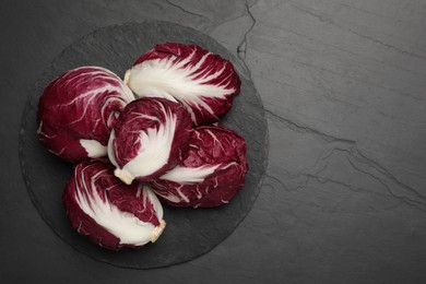 Photo of Whole fresh ripe radicchios on black table, top view. Space for text
