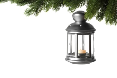 Christmas lantern with candle hanging on snowy fir tree branch against white background Photo of Christmas lantern with candle hanging on snowy fir tree branch against white background