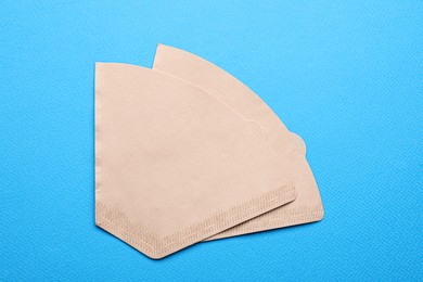 Paper coffee filters on light blue background, flat lay Photo of Paper coffee filters on light blue background, flat lay