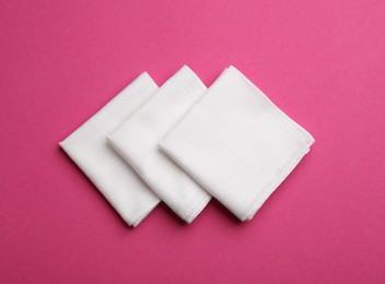 Stylish white handkerchiefs on pink background, flat lay Photo of Stylish white handkerchiefs on pink background, flat lay
